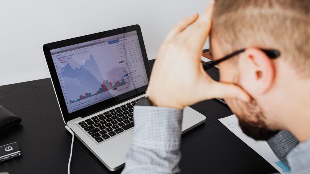 Biais cognitifs en investissement : les 10 à éviter absolument (avec parades) Investisseur stressé devant ses graphiques