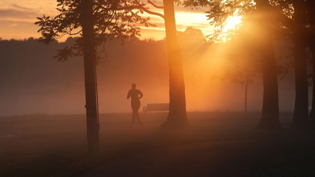 Discipline > Motivation : la méthode simple pour agir même quand tu n’as pas envie Personne qui court seule à l'aube dans la brume