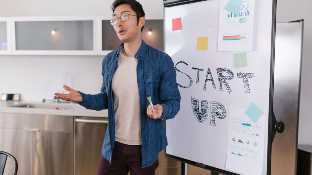 Échouer vite, gagner plus : pourquoi les meilleurs entrepreneurs ratent plus que toi Entrepreneur qui présente son projet de startup devant un tableau