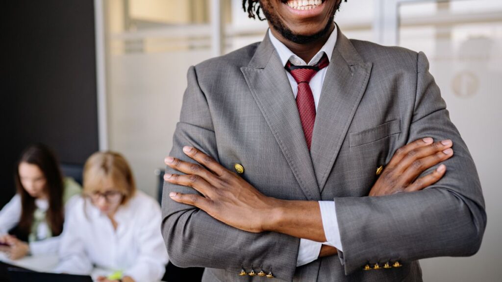Le Mindset des 1 % : 12 habitudes que les jeunes Africains qui réussissent ne disent jamais Homme d'affaires africain confiant, bras croisés
