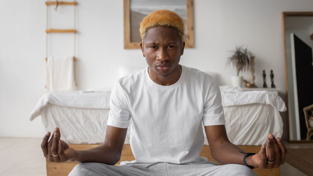 Jeune homme africain qui médite chez lui