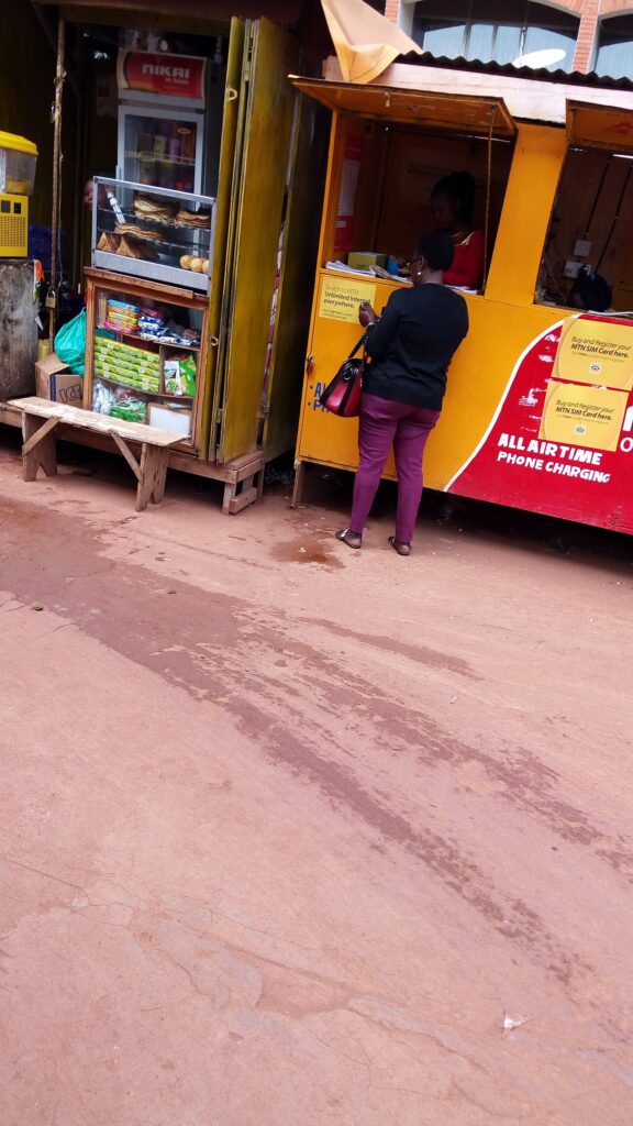 Plafond Orange Money, Wave et MTN MoMo : limites et comment les augmenter Femme dans un kiosque Mobile Money